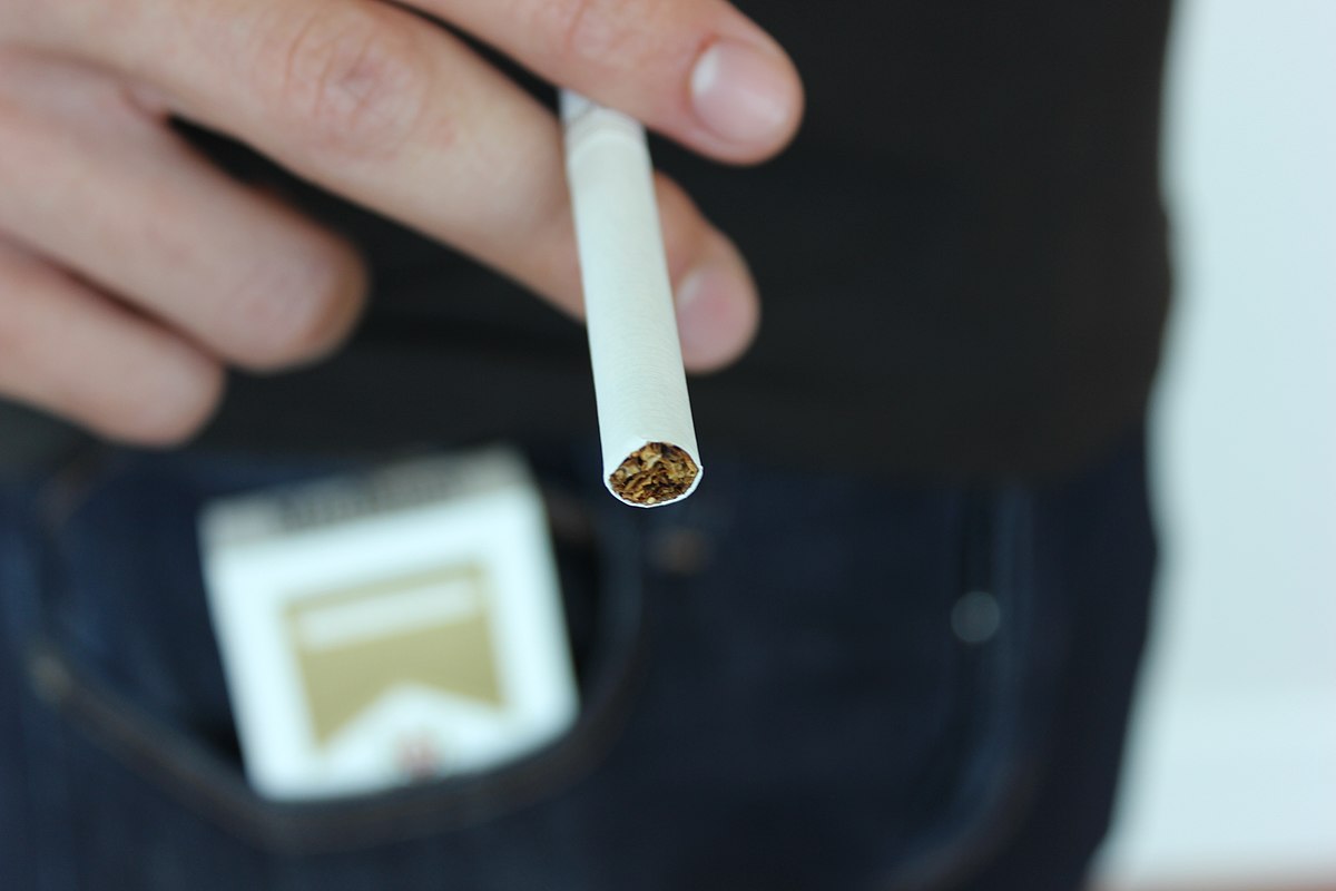 Persona amb una cigarreta de tabac a la mà.