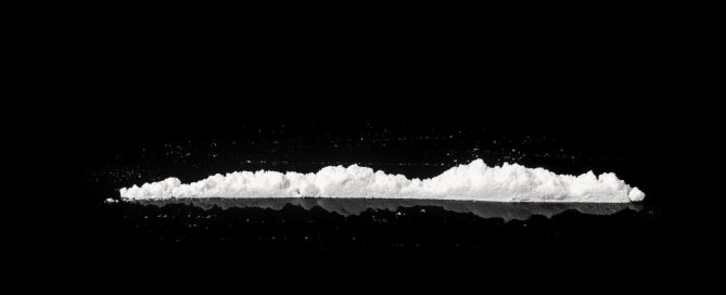 Una ratlla de cocaïna obre fons negre, representant l'addicció