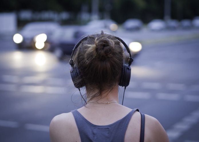 Noia amb auriculars escoltant
