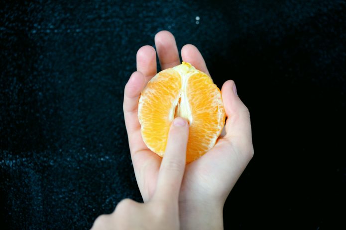 metàfora visual del consentiment amb una mà tocant una fruita que simbolitza límits i decisió en el sexe